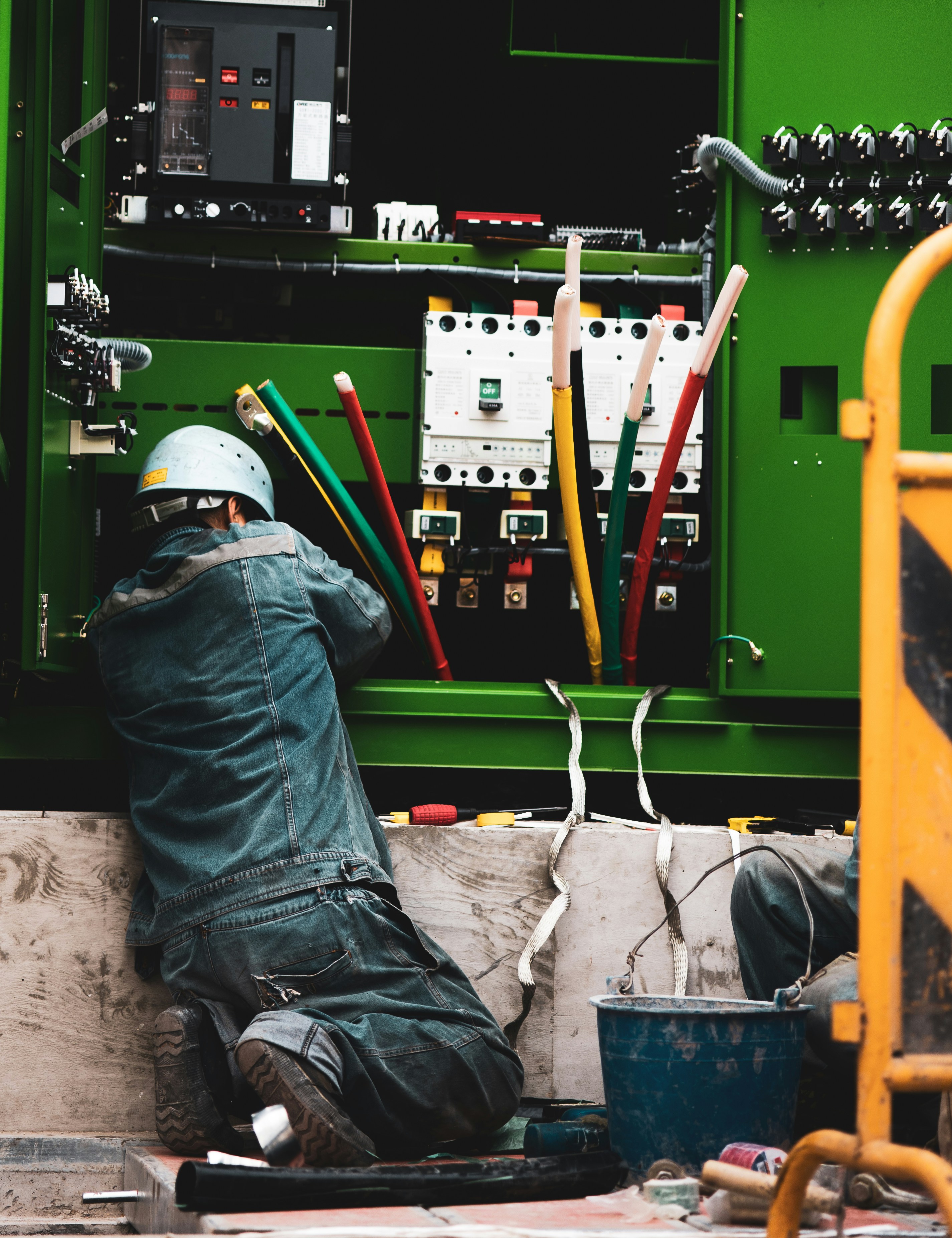 Two professional maintenance technicians in safety gear servicing commercial power equipment at facility in Nigeria